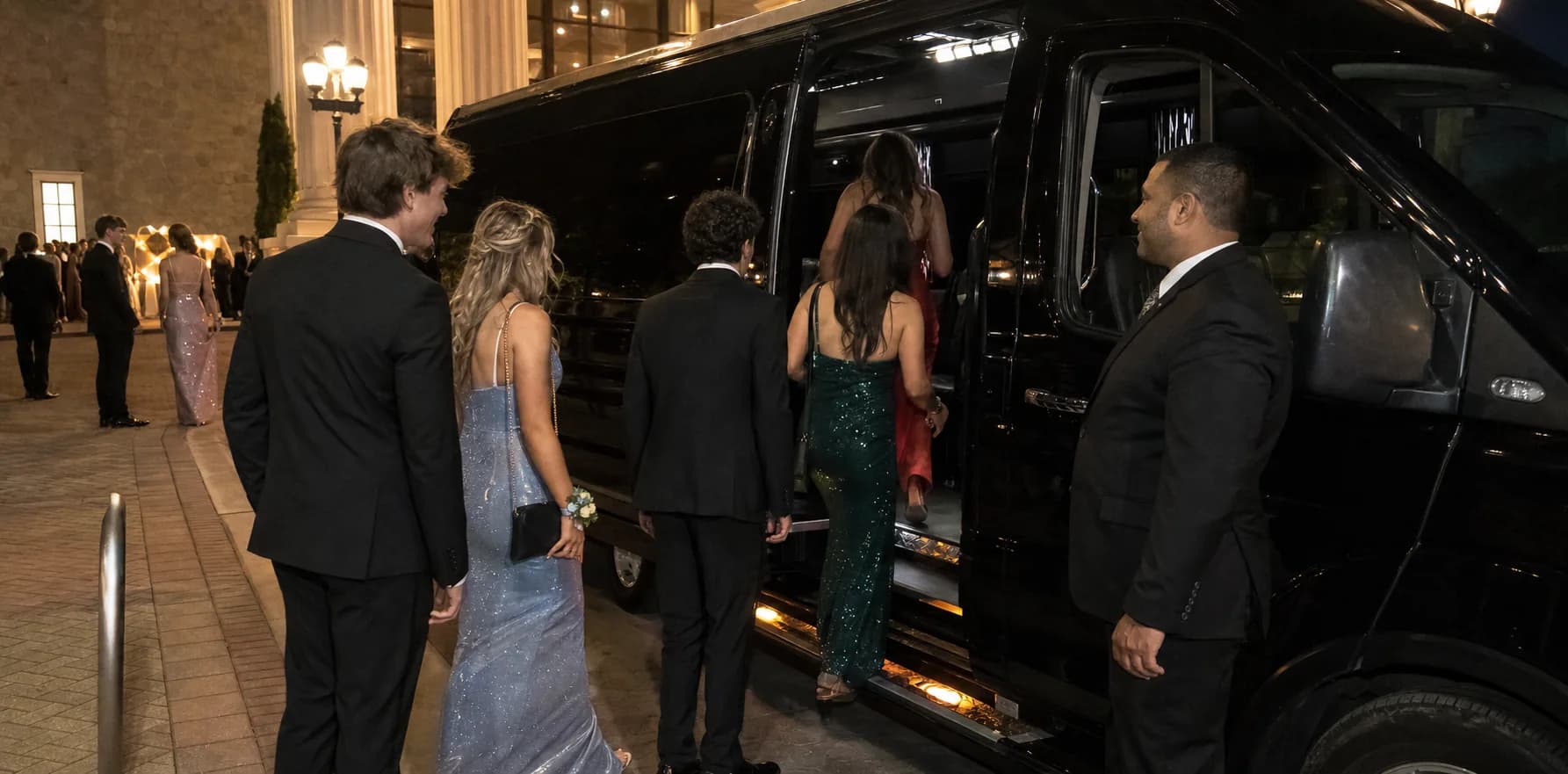 Group of prom students boarding a black executive group vehicle.